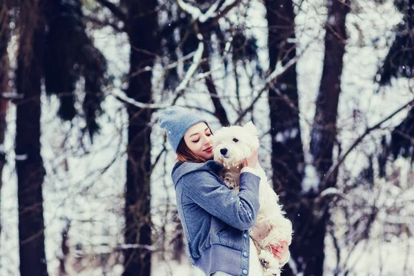 wonderful woman hugging a dog in a winter park