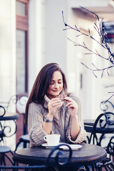 woman in sweater sitting in a cafe