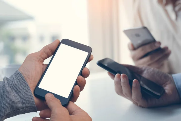 Mock up image of young men or hipsters using mobile smartphone together,  social media communication, checking internet application on smartphone, digital software development, close up