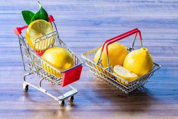 Supermarket basket and supermarket cart carrying green leaf and lemon