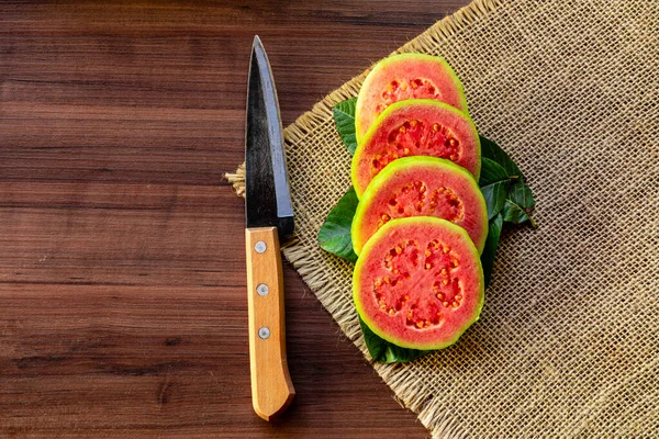 Cuchillo Acero Antiguo Guayabas Rojas Rodajas Sobre Fondo Rústico Madera — Foto de Stock