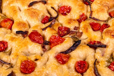 Çeri domatesli, siyah zeytinli ve biberiyeli geleneksel İtalyan Focaccia.