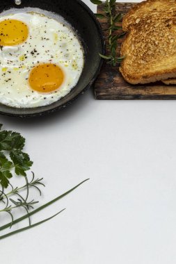 Kırsal demir bir tavada kızarmış yumurta, kahvaltıda kızarmış ekmek. kopyalama alanı. Üst görünüm.