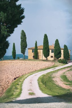 Tarım alanları ve ev ile etkileyici Tuscany görünümü. İtalyan kırsal renkli sonbahar sezonu. Dağlar, İtalya ile arka plan. Açık havada dikey görüntü
