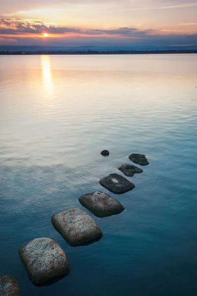 Látványos naplemente a vízen a kövek színes Cloudscape b — Stock Fotó