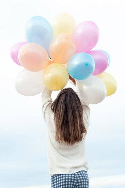 Çok renkli balonlar demet ile mutlu genç kız sk ulaşan