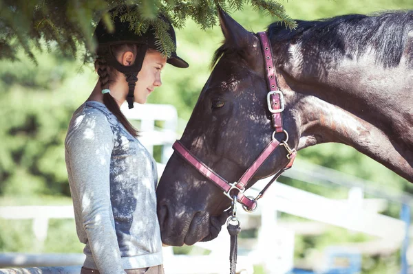 Jovencita ecuestre mirando con amor a su caballo castaño — Foto de Stock