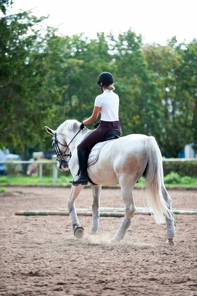 Young teenage girl equestrian practicing horseback riding on man — Stock Photo, Image