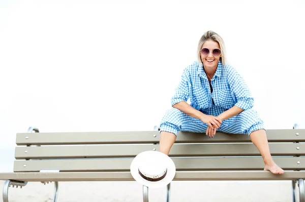 夏のサングラスをベンチに座ってかなり若い陽気な女性 屋外夏の水平色の画像 — ストック写真