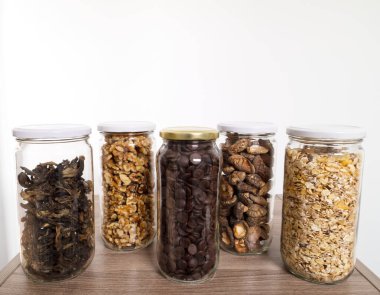 Toplu yiyecekler cam kavanozlarda saklanıyor: kuru yabani mantarlar, müsli, çikolata ve fındık. Sıfır atık.