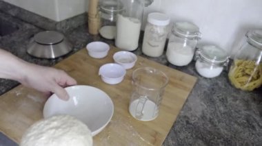 Tanınmayan bir adam ekmek hamurunu kabın içine koyuyor ki yükselsin. Ev yapımı ekmek kavramı.