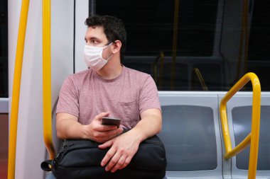 Madrid 'in yeraltında maske takan beyaz bir genç. Madrid yeraltı, yeni normallik.
