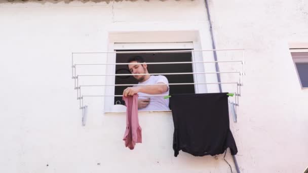Genç Beyaz Bir Adam Giysileri Pencereden Asıyor Çamaşır Konsepti — Stok video