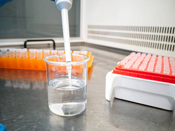 Lab technician using an electronic pipette. Researcher and laboratory concepts.