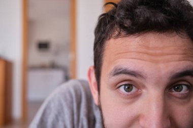 Evdeki kanepede uzanmış beyaz, yakışıklı bir gencin gözleri. Ev hayatı kavramı.