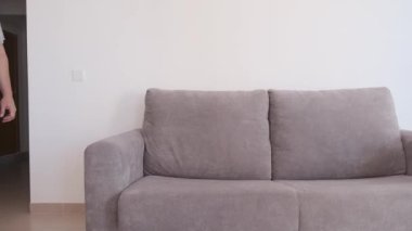 Genç adam işten yorgun geliyor ve kanepeye düşüyor. Zor gün konsepti.