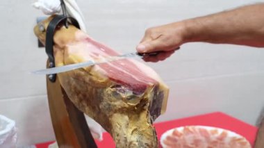 Kıdemli adam jambon bıçağıyla İberya jambonu kesiyor. İspanyol gastronomi kavramı.