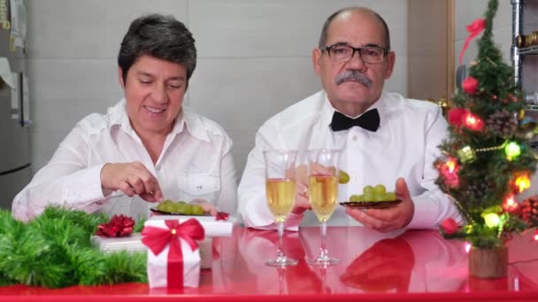 新年を祝うシニアカップルはブドウを食べる スペインの新年の伝統 クリスマスお祝いのコンセプト — ストック動画