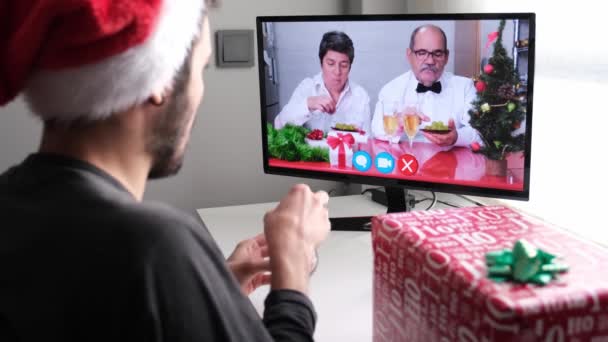 ビデオ通話で息子と一緒にブドウを食べる新年を祝うシニアカップル スペインの新年の伝統 クリスマスお祝いのコンセプト — ストック動画