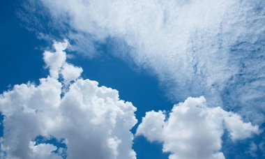 Beyaz bulutlar mavi gökyüzü arka planına karşı. Güneşli bulutlu yaz günü.