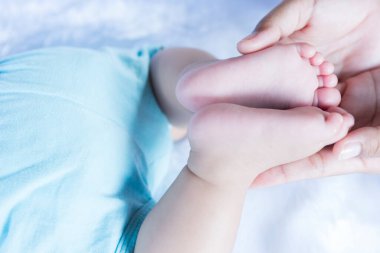 Bebek ayakları ebeveynin ellerinde. Babası ve çocuğu. Yeni doğmuş bebeğin ayakları. Mutlu aile ve ebeveynlik kavramı.