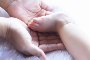 Bebek ayakları ebeveynin ellerinde. Babası ve çocuğu. Yeni doğmuş bebeğin ayakları. Mutlu aile ve ebeveynlik kavramı.