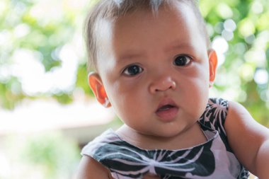 Küçük tatlı bir kız kameraya bakıyor..