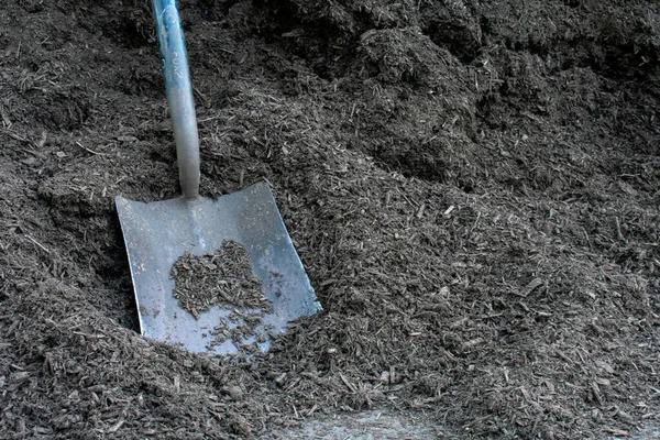Large Black Square Shovel Resting Pile Black Woodchip Mulch — Stok Foto