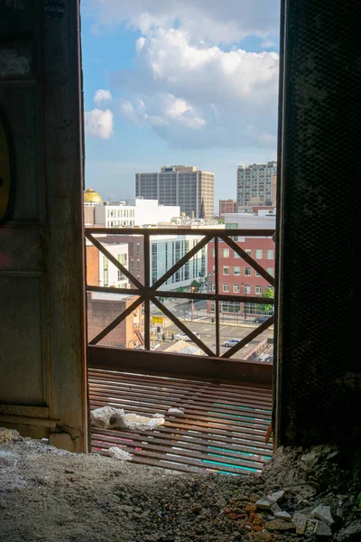 街のスカイラインの古い放棄された建物のオープンドアを見る — ストック写真
