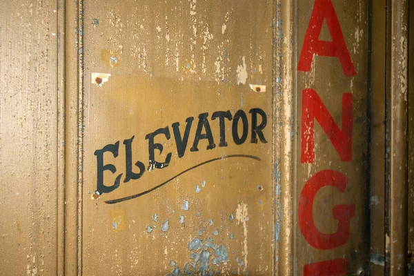 An Old Fashioned Door With Text That Says Elevator on It