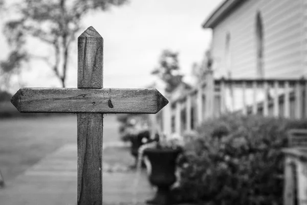 Christian Church Background. Wooden cross in front and exterior of a small rural country church in the heart of the American Midwest.