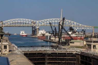 Sault Ste Marie, Michigan, USA - Large Great Lakes freighters line up at the Soo Locks under the International Bridge. The Soo Locks is one of the busiest shipping channels in the world.