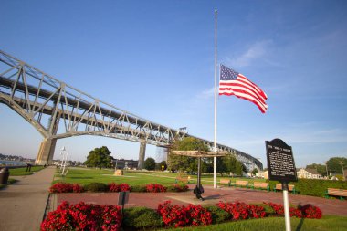 Port Huron, Michigan, ABD - 10 Ekim 2018: Waterfront Parkı ve şehir Port Huron Michigan arka planda mavi su uluslararası köprünün İki Yataklı açıklıklı ile marker tarihsel.