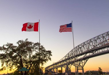International Border Crossing. Sunset at the Blue Water Bridge border United States and Canada crossing. The bridge connects Port Huron, Michigan and Sarnia, Ontario. clipart