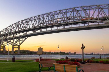 Blue Water Bridge Sunrise. Dawn over the towns of Port Huron, Michigan and Sarnia, Ontario on the US and Canadian border connected by the twin spans of the Blue Water Bridge. clipart