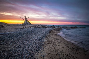 Michigan Gölü üstün günbatımı manzara. Gün batımı ufuk üzerinde wild coast Lake Superior ve ilkel plaj kulübe arka plan ve ön planda gölün mavi su ile.