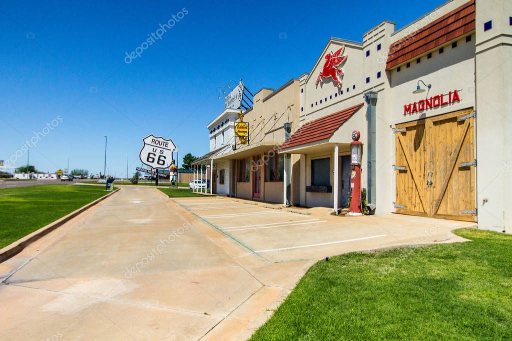 Elk City, Oklahoma, USA - April 27, 2019: Historic Mobil gas station facade in downtown Elk City along the historic Route 66 Highway with large Route 66 in the background.