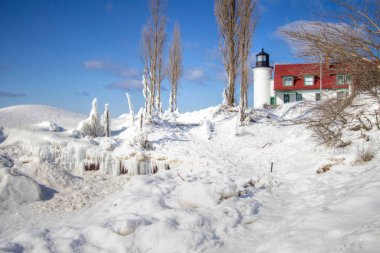 Büyük Göller 'deki Kış Deniz Feneri. Michigan Gölü kıyısında güzel bir kış manzarası. Point Betsie Deniz feneri Uyuyan Ayı Kumulları Ulusal Lakeshore yakınlarında batan güneşin parıltısıyla yıkandı.. 