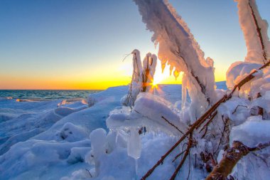 Michigan Gölü kıyısında buz oluşumları. Sleeping Bear Dunes Ulusal Lakeshore kıyısında buz oluşumları ile Michigan Gölü kıyısında güzel günbatımı. 