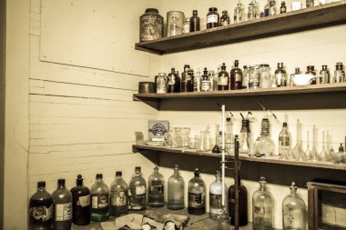 Tombstone, Arizona, ABD-1 Mayıs 2019: Tombstone Adliye Eyaleti tarihi Parkı 'nda bir eczanede ilaç ve ilaç şişeleri antika şişeleri raflar. 