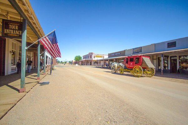 Tombstone, Arizona, USA - May 1, 2019: Stagecoach and Wild West style storefront facades on the streets of historic Tombstone. The ghost town turned tourist destination draws over 400,000 tourists annually