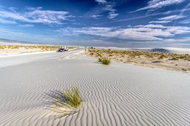 Alamogordo, New Mexico, ABD - Beyaz Kumlar New Mexico 'nun sert çöl manzarasında bir SUV çekicisi.