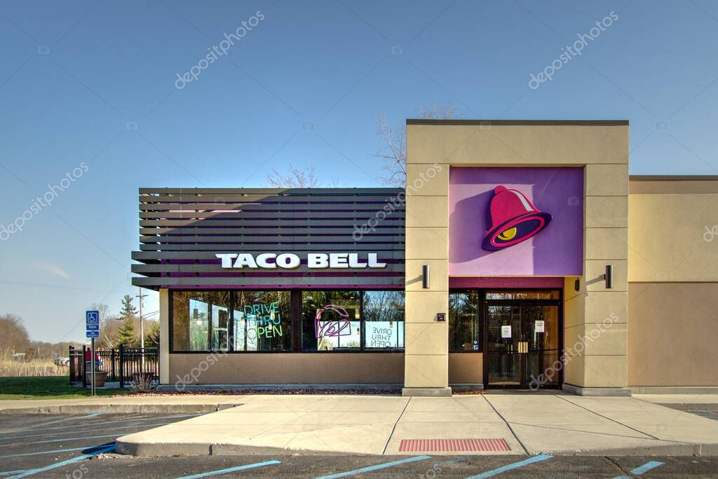 Port Huron, Michigan, USA - May 13, 2020: Exterior of Taco Bell Restaurant with empty parking lot and closed dining room due to the Covid 19 pandemic.