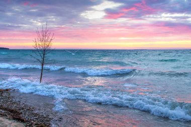 Michigan Gölü Günbatımı. Michigan 'daki Michigan Gölü kıyılarının mavi sularına canlı günbatımı renkleri yansıdı.