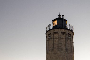 Kopya Boşluğu ile aydınlatılmış Deniz feneri. Mackinaw Point Deniz feneri, Michigan 'ın Büyük Gölleri kıyısındaki fırtınalı bir akşamda Mackinaw Boğazı' nın üzerinde parlıyor..
