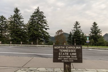 Gatlinburg, Tennessee 'deki Great Smoky Dağları Ulusal Parkı' ndaki Yeni Bulunmuş Gap Yolu 'nda Kuzey Carolina ve Tennessee eyalet sınırı tabelası..