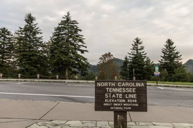 North Carolina and Tennessee state line sign on the Newfound Gap Road in the Great Smoky Mountains National Park in Gatlinburg, Tennessee. clipart
