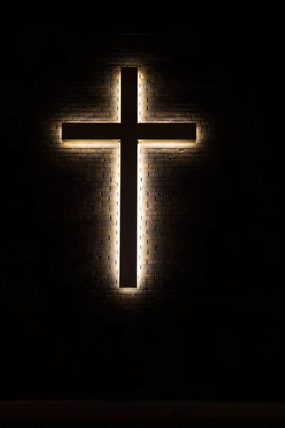 Christian Crucifix. Illuminated Christian cross in vertical orientation.