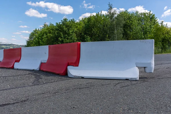 Barreras rojas y blancas que bloquean una carretera —  Fotos de Stock