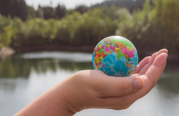 Decorative little globe hold in one hand — Stock Photo, Image